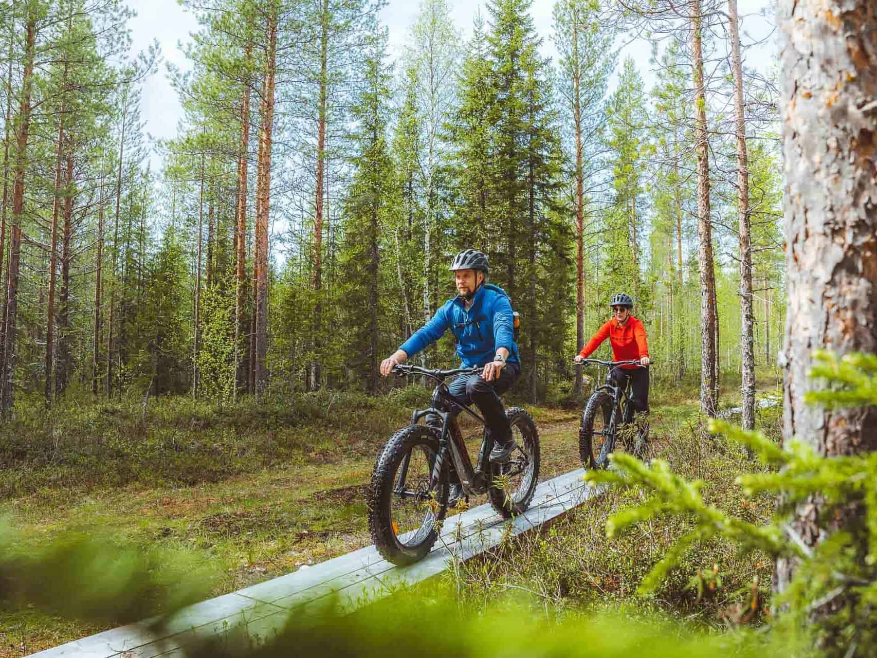 two people driving e-fatbikes on duckboards
