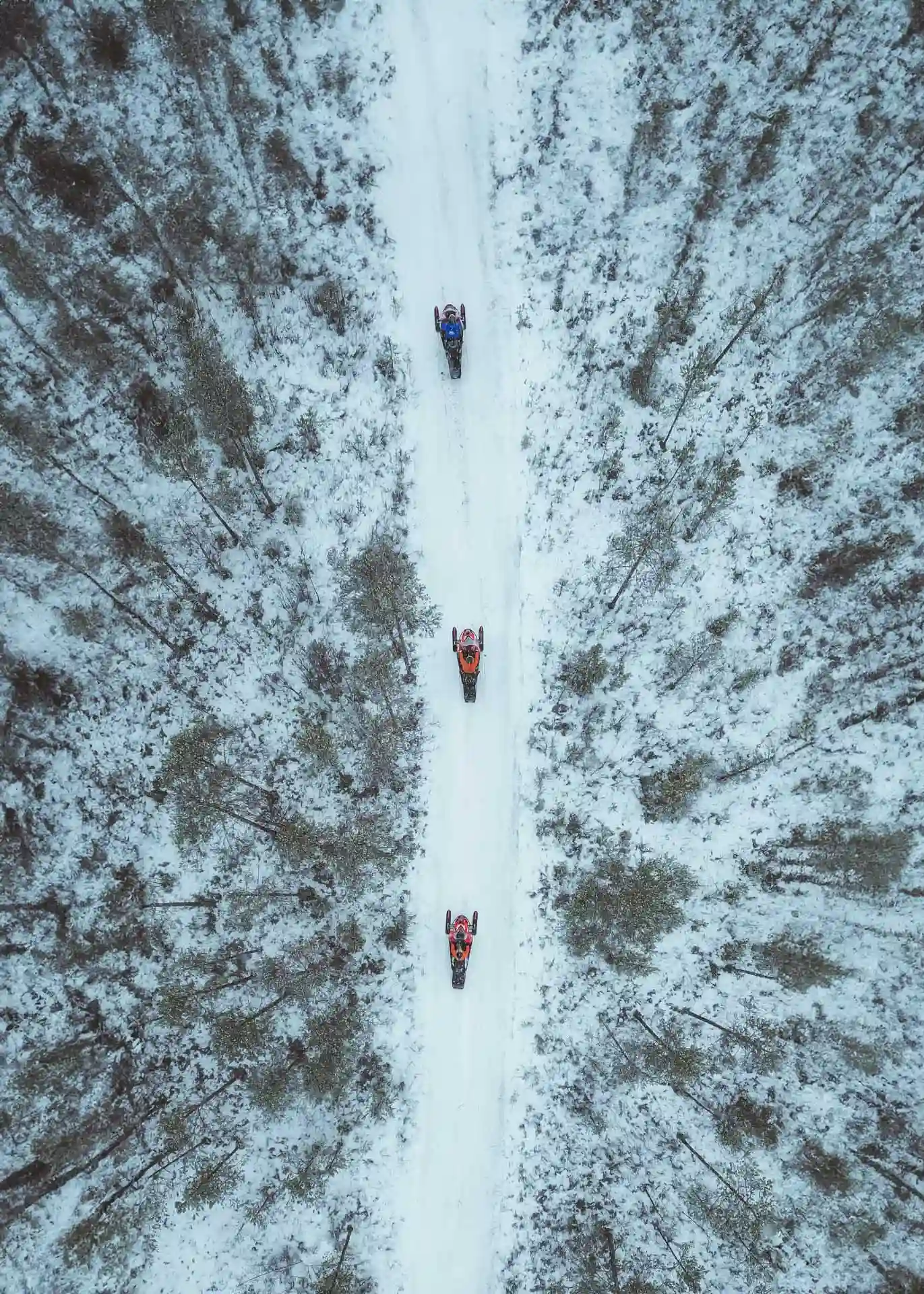 Top-down view of three snowmobiles in early winter Lapland