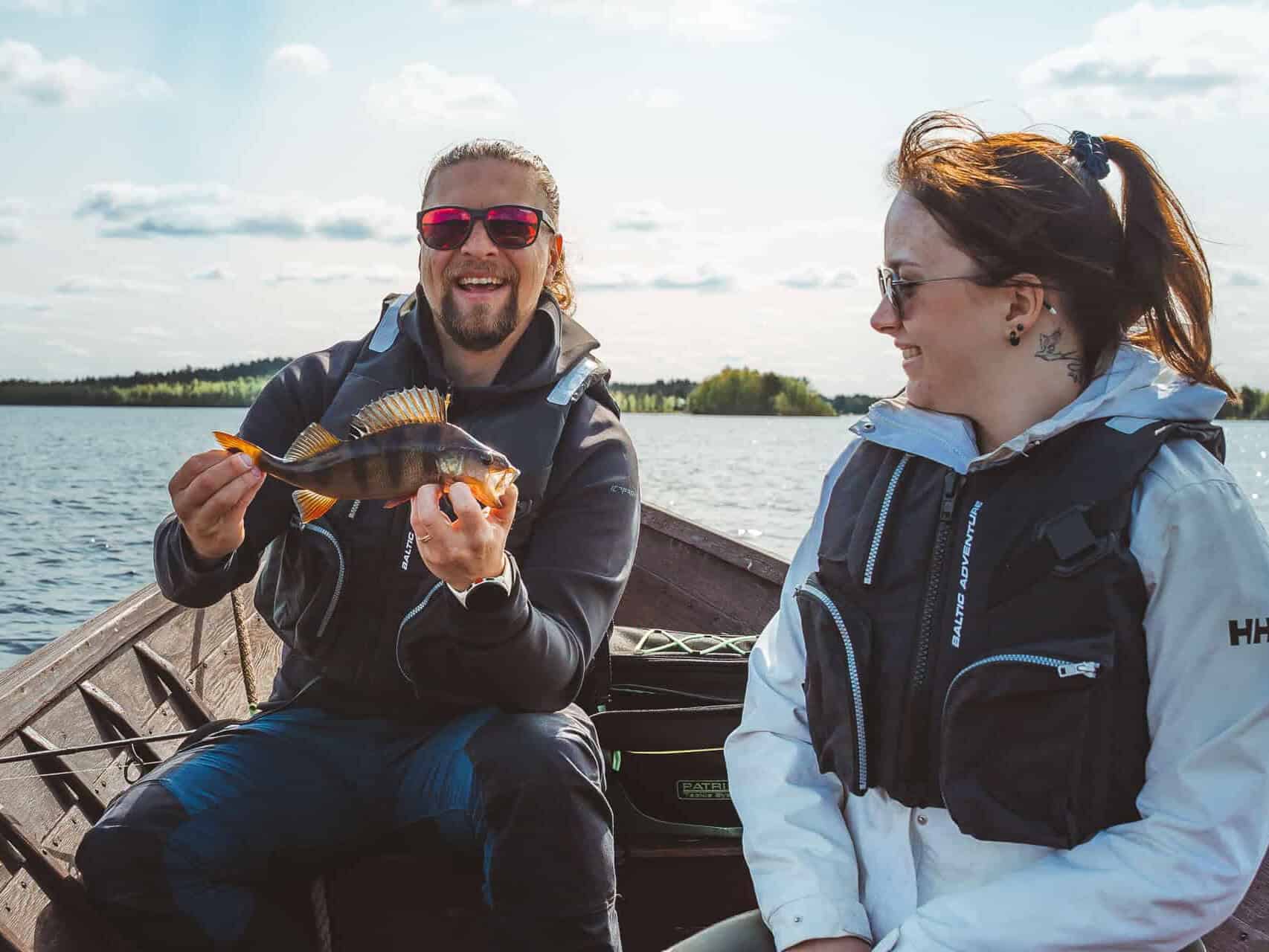 smiling guests on a boat after catching a fish